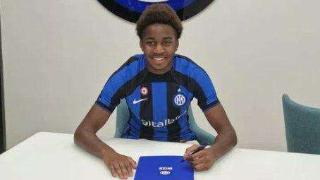 Yvan Kouadio sorridente firma il suo nuovo contratto con l'Inter