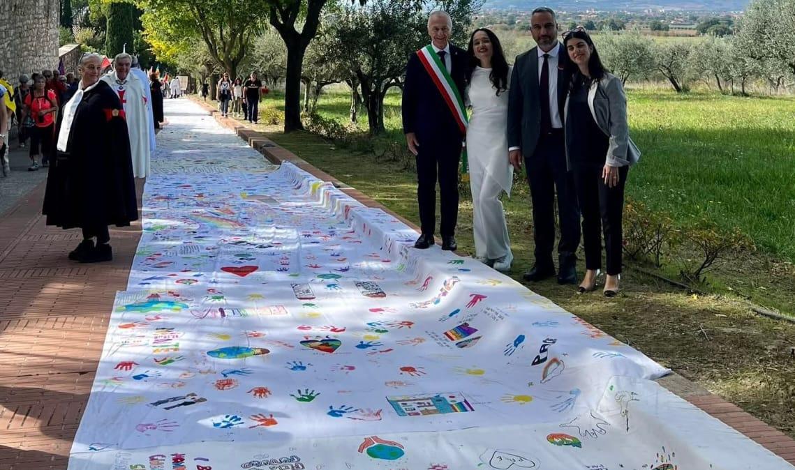 L'artista umbra Moira Lena Tassi si gode le emozioni alla Marcia PerugiAssisi con la sua Eco-Bandiera della Pace